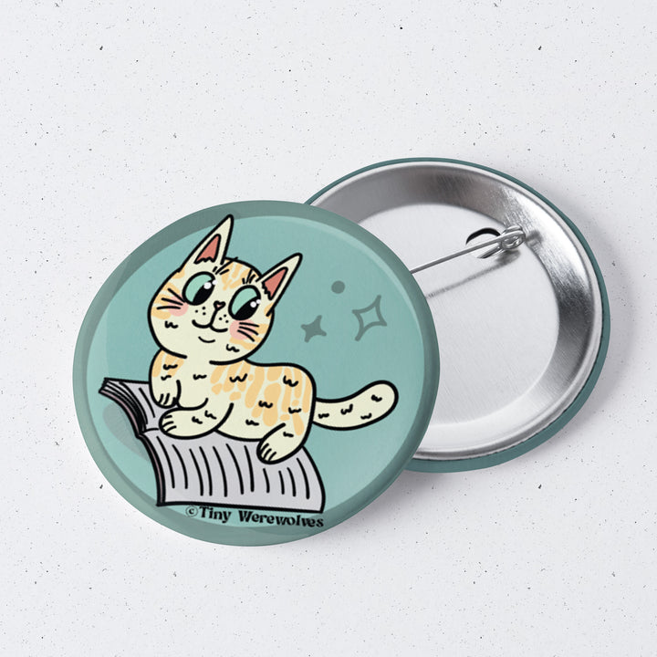 Based in Chicago by queer artist & designer Kayla Pekkala - Tiny Werewolves | Orange Book Cat 1" Mini Button Pin in | Shop to get your Metal Pinback Button with collections featuring retro-inspired designs infused with social commentary art, highlighting modern social & current events.