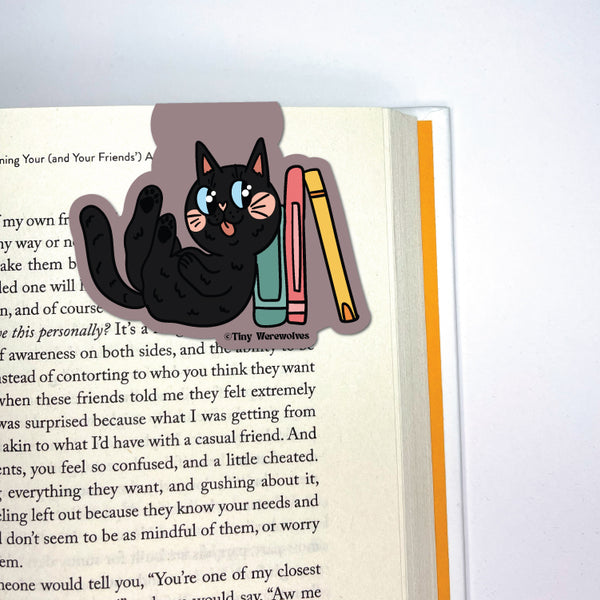 Based in Chicago by queer artist & designer Kayla Pekkala - Tiny Werewolves | Black Book Cat Laminated Magnetic Bookmark in | Shop to get your Magnetic Bookmark with collections featuring retro-inspired designs infused with social commentary art, highlighting modern social & current events.