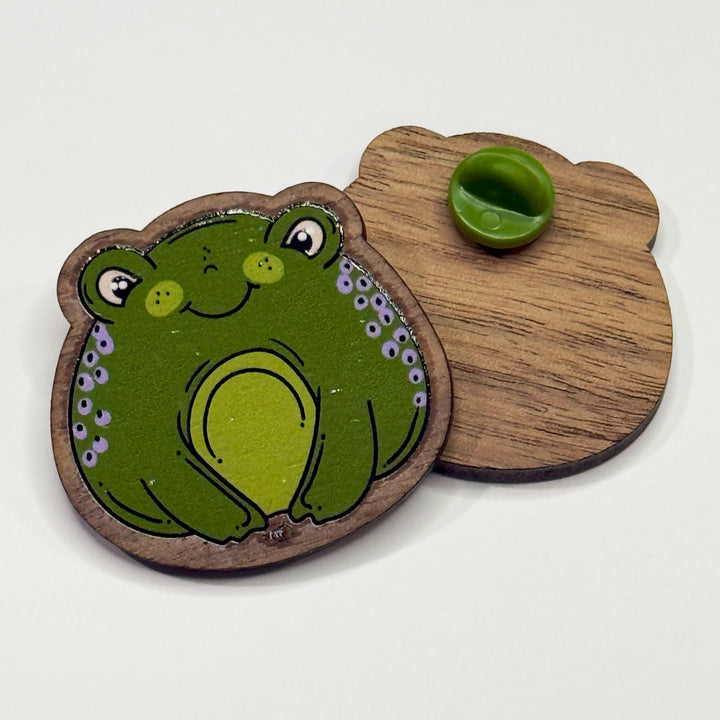 Based in Chicago by queer artist & designer Kayla Pekkala - Tiny Werewolves | Frog Wood Pin in | Shop to get your Wood Pin with collections featuring retro-inspired designs infused with social commentary art, highlighting modern social & current events.