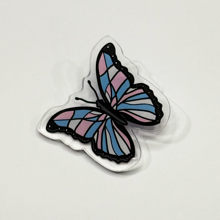 Based in Chicago by queer artist & designer Kayla Pekkala - Tiny Werewolves | Trans Pastel Subtle Queer Butterfly Acrylic Pin in Clear | Shop to get your Acrylic Pin with collections featuring retro-inspired designs infused with social commentary art, highlighting modern social & current events.