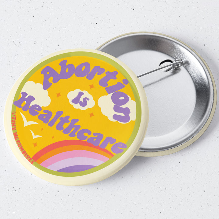 Based in Chicago by queer artist & designer Kayla Pekkala - Tiny Werewolves | Abortion Is Healthcare 1.75" Button Pin in | Shop to get your Metal Pinback Button with collections featuring retro-inspired designs infused with social commentary art, highlighting modern social & current events.