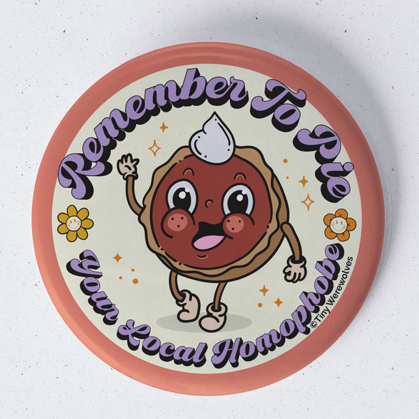 Based in Chicago by queer artist & designer Kayla Pekkala - Tiny Werewolves | Pie Your Local Homophobe 1.75" Button Pin in | Shop to get your Metal Pinback Button with collections featuring retro-inspired designs infused with social commentary art, highlighting modern social & current events.