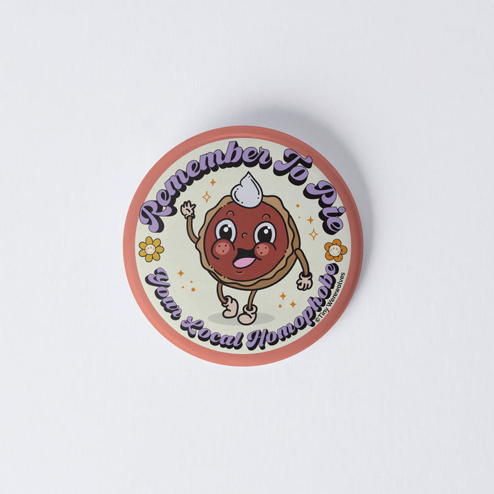 Based in Chicago by queer artist & designer Kayla Pekkala - Tiny Werewolves | Pie Your Local Homophobe 1" Mini Button Pin in | Shop to get your Metal Pinback Button with collections featuring retro-inspired designs infused with social commentary art, highlighting modern social & current events.