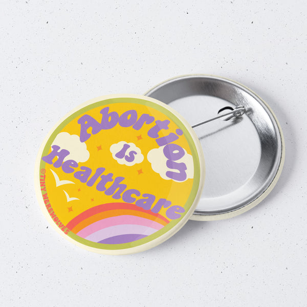 Based in Chicago by queer artist & designer Kayla Pekkala - Tiny Werewolves | Abortion Is Healthcare 1" Mini Button Pin in | Shop to get your Metal Pinback Button with collections featuring retro-inspired designs infused with social commentary art, highlighting modern social & current events.
