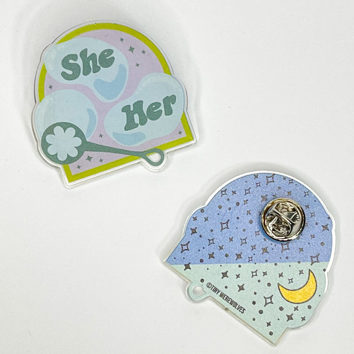 Based in Chicago by queer artist & designer Kayla Pekkala - Tiny Werewolves | She / Her Pronouns Bubble Acrylic Pin in Clear | Shop to get your Acrylic Pin with collections featuring retro-inspired designs infused with social commentary art, highlighting modern social & current events.