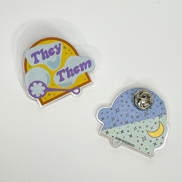 Based in Chicago by queer artist & designer Kayla Pekkala - Tiny Werewolves | They / Them Pronouns Bubble Acrylic Pin in Clear | Shop to get your Acrylic Pin with collections featuring retro-inspired designs infused with social commentary art, highlighting modern social & current events.